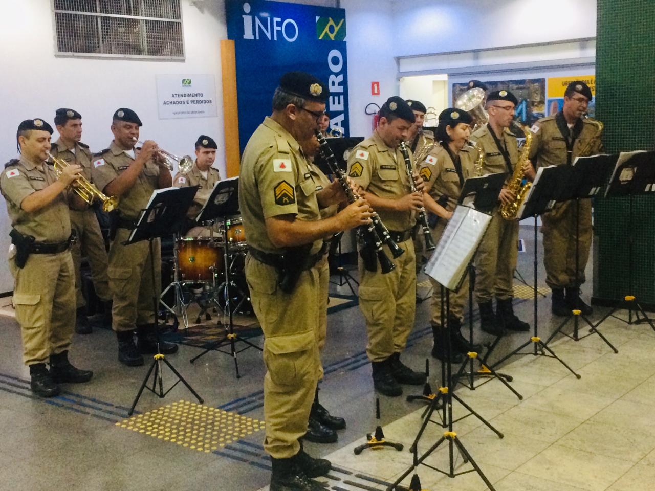 Policiais da banda da Polícia Militar de Uberlândia se apresentam no saguão do aeroporto de Uberlândia